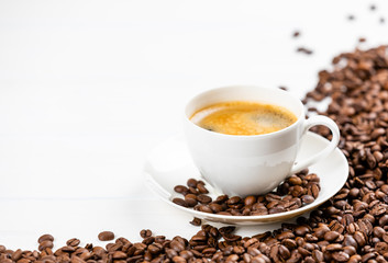 Fototapeta premium coffee cup with coffee beans on a white wooden background