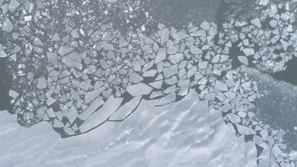 Aerial view of texture of broken blue ice and water at winter. 	
