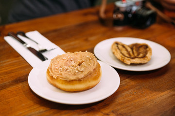Brown Sugar Glazed Apple Cinnamon Baked Donuts in white plate on wooden table.