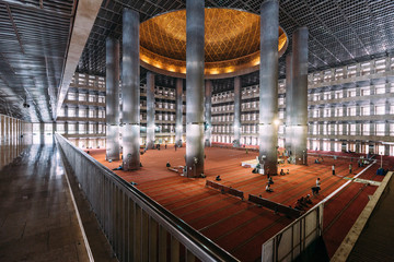 Masjid Istiqlal Interior with prayers in Indonesia is the largest mosque in Southeast Asia. Named "Istiqlal", an Arabic word for "independence"