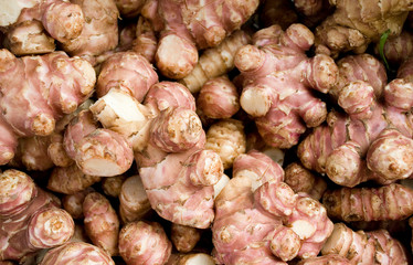 roots of Jerusalem artichoke or topinambour, brown and red, at local market of vegetables, texture,...