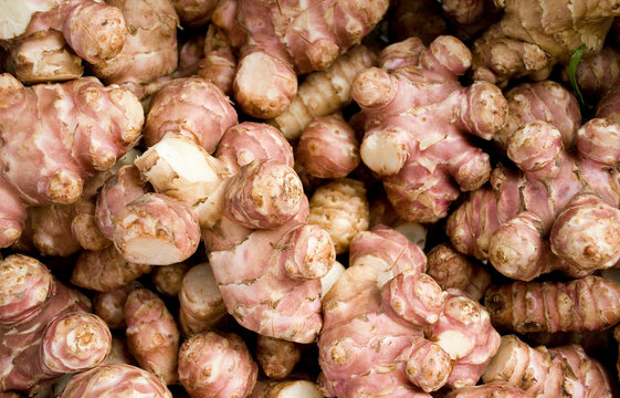 roots of Jerusalem artichoke or topinambour, brown and red, at local market of vegetables, texture, agriculture, cultivation, food, diet, vitamins, nourishment, nutrition, Milan, Italy