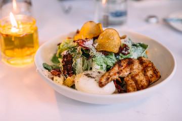 Ceasar salad served with boiled egg, chips and grilled chicken breast.