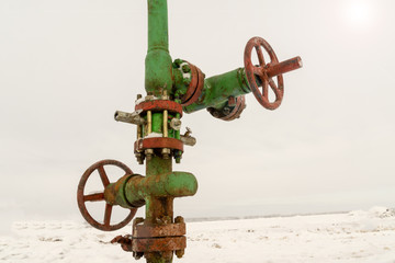 Horizontal view of a wellhead with valve armature. Oil and gas industry concept.  Oil valve with...