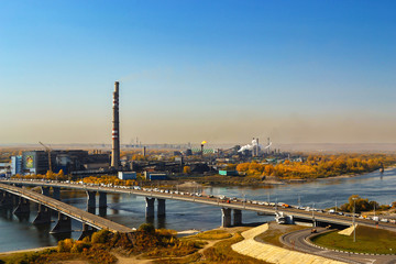 Kemerovo, Russia, 09.21.2011: Kuznetsky Bridge with transport, polluting the atmosphere of a plant on the river bank