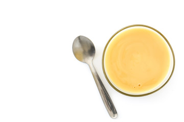 Bowl of homemade vanilla custard isolated on white background. Top view. Copyspace