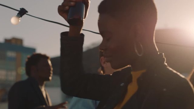 young woman dancing group of diverse friends hanging out together enjoying rooftop party at sunset drinking alcohol having fun on weekend celebration