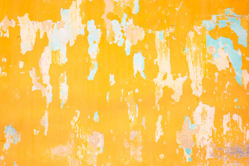 Cracked and peeling paint on yellow wall.
