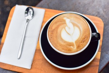 Hot Caffe Latte with Foam Art in a Black Cup