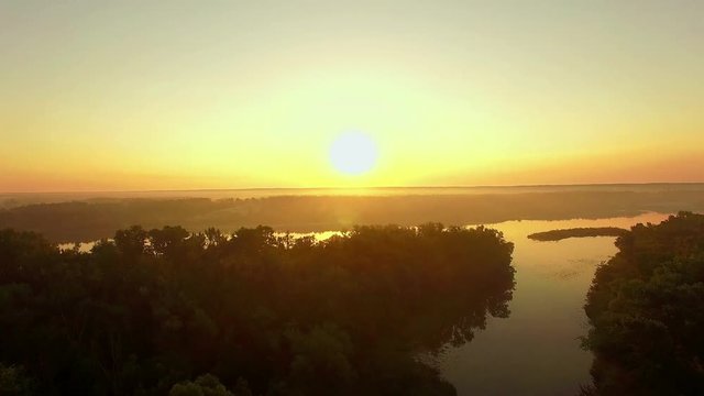 aerial view of river at sunrise, forest and river in morning mist,  Flying over the river green trees at sunrise, Aerial view of mystical river at sunrise with fog
