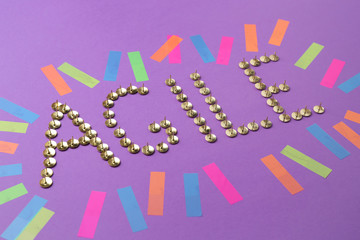 Word AGILE made of thumbtacks on color background