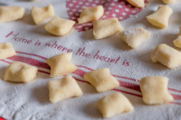 display of  fresh traditional  homemade italian gnocchi pasta on table with flour