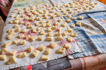 display of  fresh traditional  homemade italian gnocchi pasta on table with flour