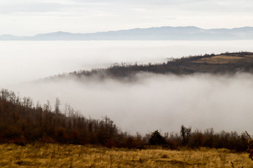 Fototapeta na wymiar Foggy landscape of hills, mountains and forest in place called Tresibaba, near city Knjazevac, Serbia, Landscape winter hill scene with fog