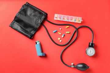 Sphygmomanometer and drugs on color background. Health care concept