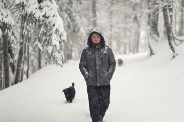 Fototapeta na wymiar traveler hiking trip in the snow when life is better in the woods with dogs