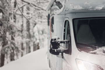 campervan caravan vehicle for van life holiday on camper van journey camping in mountains near the forest in the winter adventure season. snowing on the camper outdoor nomad lifestyle