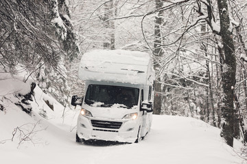 Naklejka premium camping car or campervan outdoor on the mountain side offroad near the forest in the winter snowing