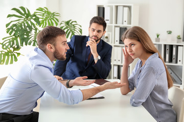Young emotional couple visiting divorce lawyer in office