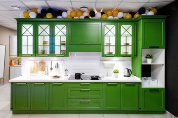 Classic kitchen interior with green trim. Kitchen acrylic countertop with built-in sink.