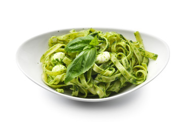 Plate with tasty pesto pasta on white background