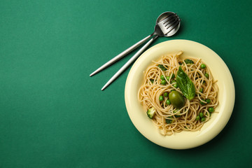 Plate with tasty pasta on color background
