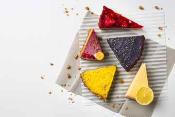 Pieces of tasty cakes on white table