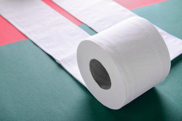 Roll of toilet paper on color background