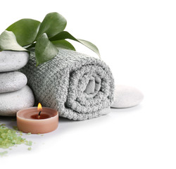 Fototapeta na wymiar Beautiful spa composition with stones, towel and candle on white background
