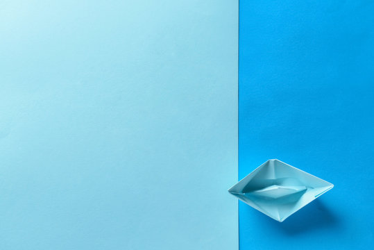 Origami boat on color background