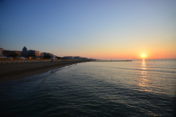 the sun is rising on the Adriatic sea and on the beautiful beach of jesolo, in the province of Venice in Italy