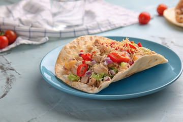 Plate with tasty taco on light table