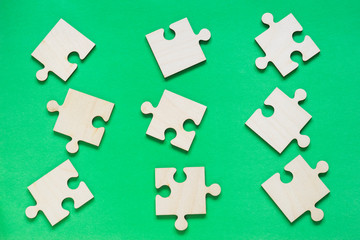 Wooden puzzle on the green background.