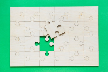 Wooden puzzle on the green background.
