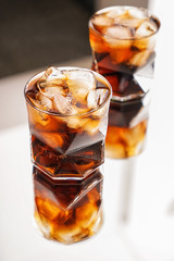 Glasses of tasty cold cola drink on table