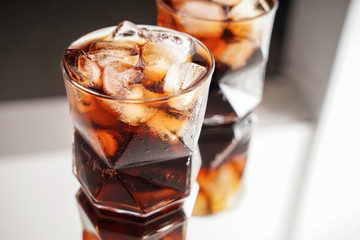 Glasses of tasty cold cola drink on table