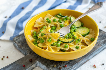 Farfalle pasta with zucchini and green peas.