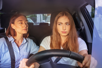 Teenage girl during driving lesson in a car