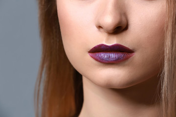 Fototapeta premium Young woman with makeup in violet tones, closeup