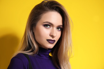 Fashionable young woman on color background