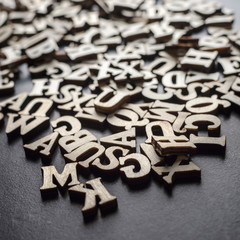 Wooden alphabets on a dark woode background