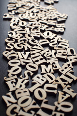 Wooden alphabets on a dark woode background