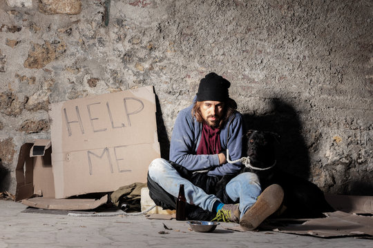 Homeless man sitting on the street with a dog