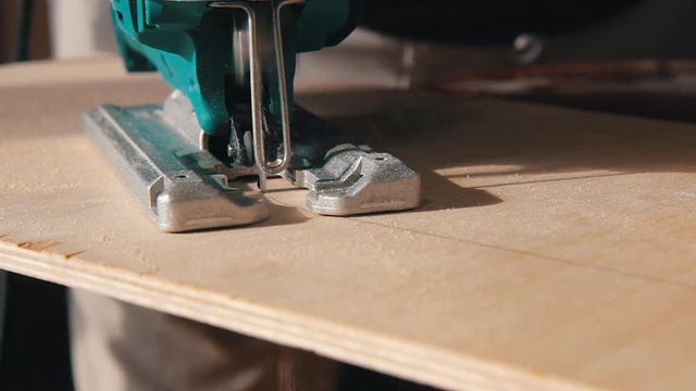 Plywood cutting. Working with  electric fret saw.  cut across the radius
