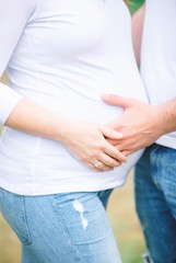 pregnant woman touching her belly with hands