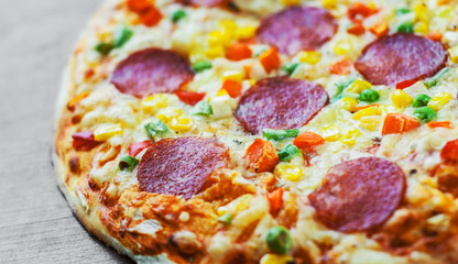 Pizza with vegetables mix, Mozzarella cheese, pepperoni, tomato, salami. Italian pizza on wooden table background