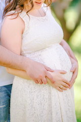 Fototapeta na wymiar men's hands hugging the belly of a pregnant woman