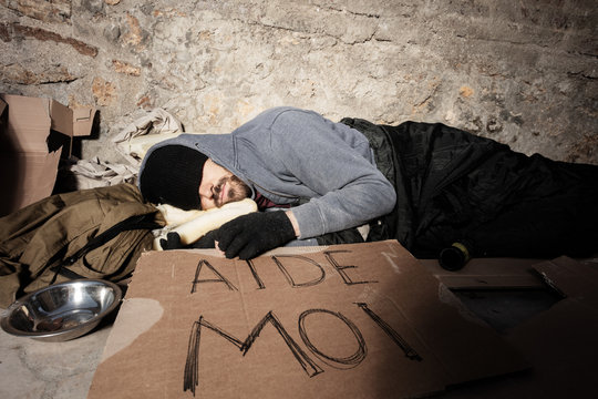 Homeless man in old clothes sleeping on the street