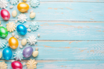 Obraz premium Easter colored eggs with sweets on a wooden texture .Flatlay. easter festive background