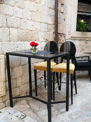 Tables and chairs of outdoor cafe in Croatia, Dubrovnik. Beautiful empty cafe with served tables
